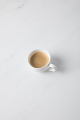 Top view of coffee cup placed on white surface