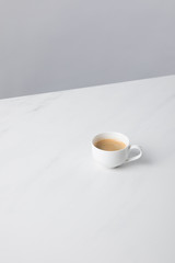 View of cup with coffee on white surface