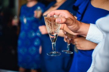 glass of wine in the hands of men at the festival