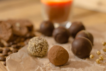 handmade chocolate candys on wooden table with chocolate bread and coffee bean decorations 