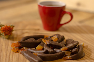candied tropic fruits with chocolate on wooden table 