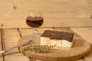 Bird's milk souffle cake with many chocolate candies on wooden table 