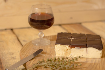 Bird's milk souffle cake with many chocolate candies on wooden table 
