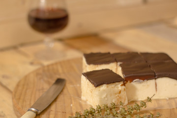 Bird's milk souffle cake with many chocolate candies on wooden table 