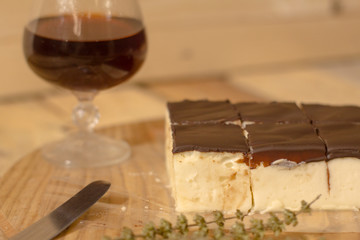Bird's milk souffle cake with many chocolate candies on wooden table 
