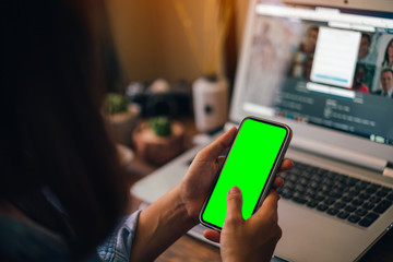 Woman holding a smartphone with green screen isolated on screen background.
