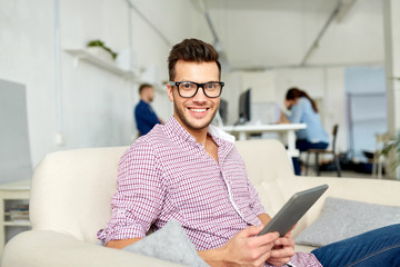 man in glasses with tablet pc working at office