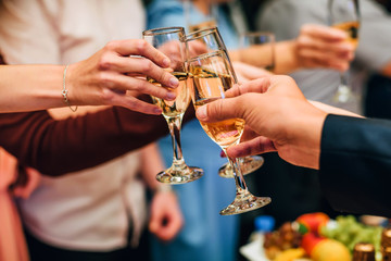 hands with glasses of champagne in the hands of successful people at the party