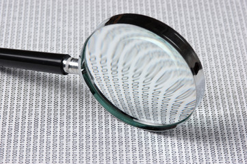magnifying glass on a binary code