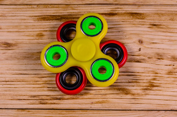 Two fidget spinners on wooden desk. Top view