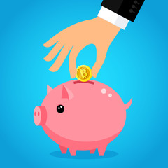 Hand putting bitcoin dollar into saving piggy bank