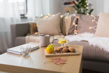 oat cookies, book, tea and lemon on table at home