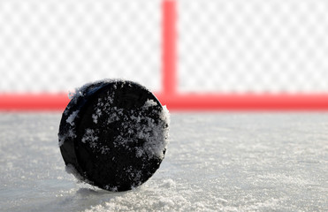 Hockey puck lying on a ice rink.