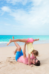 Happy dad and his little daughter at tropical beach having fun