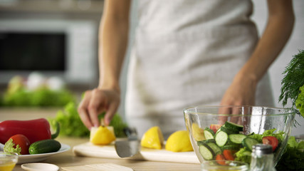 Obraz na płótnie Canvas Cooking amateur making fresh salad at home kitchen, dressing with lemon juice