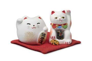 Japanese maneki neko, lucky cats on a red pillow