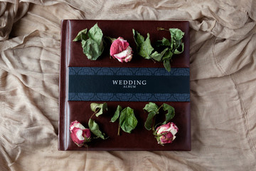 leather covered wedding photo album top view with rose flowers decoration
