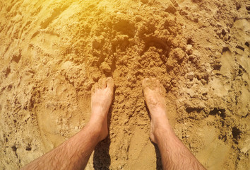 Barefoot man standing in the beach sand