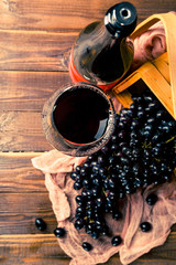 Picture on top of wine glass with wine, grapes of black, wooden basket, cloth