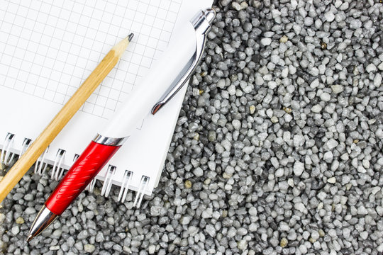 A sign-up sheet and pen on gray gravel as a background.