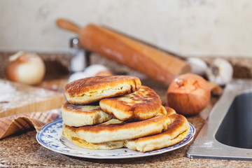 Plate with fried pies stands on marble table