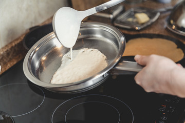 Fototapeta na wymiar liquid dough is poured onto frying pan