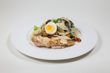 Chicken Salad with egg and cheese  on a white plate on a white background isolated