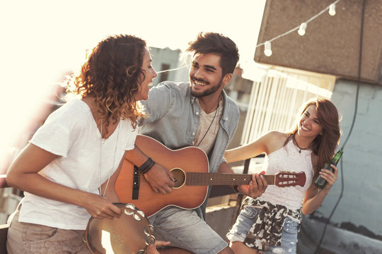 Friends Playing The Guitar And Singing