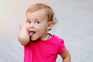 Little sweet girl trying to lick her elbow