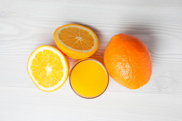 Orange juice glass with orange slices on a light wood background