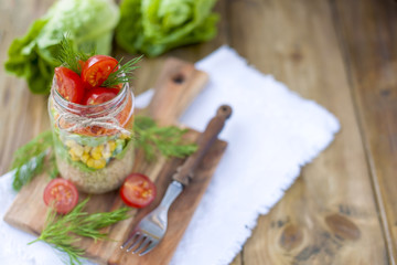 Fresh vegetable salad in a can of layers. Healthy food. Lunch at home on the table near the window. Free space for text or a postcard.