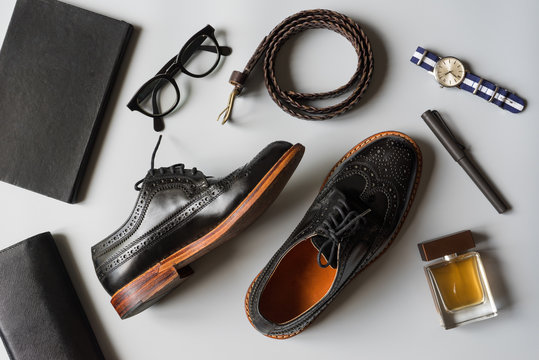 Top View Of Men Leather Shoes And Accesories In Black Tone, Wingtip Shoes On Grey Background