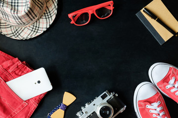 vintage fineart film photography set of red sneakers, red glasses, red jeans, vintage camera, white phone, notebook, stylus pen, checkered hat and bowtie