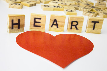 Wooden letters spelling the word HEART on white background.