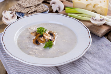 Soup with mushrooms and green onion and cheese. Healthy food. Wooden background. Family home lunch. Free space for text.