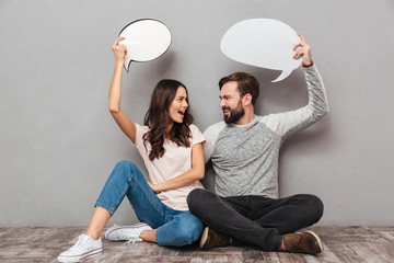 Confused man with his wife holding speech bubbles.