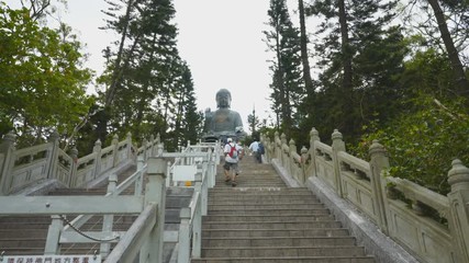a wide angle gimbal shot climbing the steps to tan tian buddha in hong kong, china