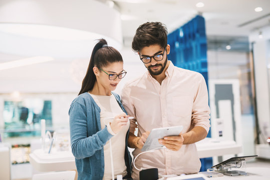 Attractive Young Couple Looking At An Electric Drawing Board In The Big Tech Shop.