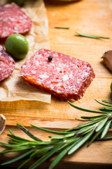 Delicious salami with olives, spices and rosemary. Selective focus.