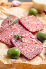Delicious salami with olives, spices and rosemary. Selective focus.