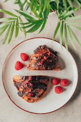top view of sweet pastry with raspberries on plate on light surface