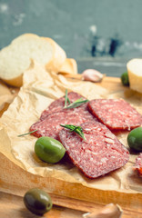 Delicious salami with olives, spices and rosemary. Selective focus.