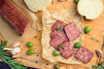 Delicious salami with olives, spices and rosemary. Selective focus.
