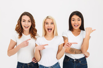 Obraz premium Portrait of three excited casual girls standing together