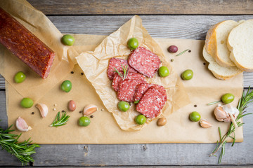 Delicious salami with olives, spices and rosemary. Selective focus.