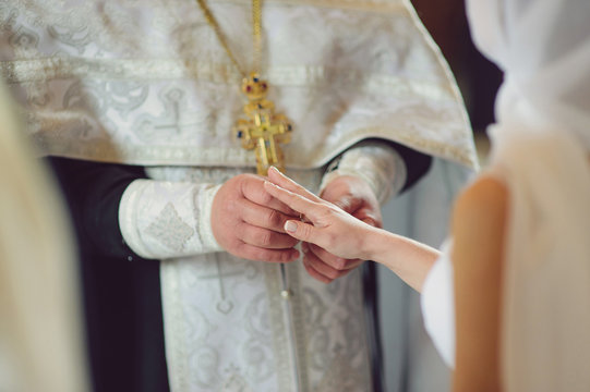 Priest Putting Wedding Ring on Bride's Hand