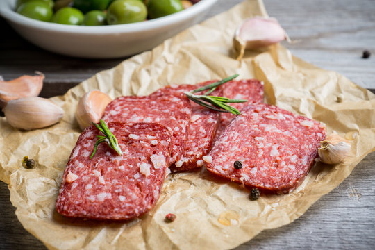 Delicious salami with olives, spices and rosemary. Selective focus.