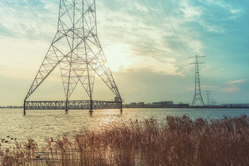 Electricity poles in the lake Buiten IJ with the Amsterdam district IJburg in the background.