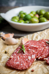 Delicious salami with olives, spices and rosemary. Selective focus.