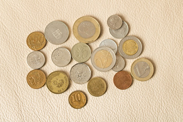 A lot of scattered coins on a leather background